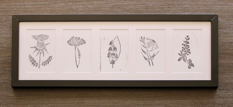 Five monochrome prints framed in a horizontal orientation. The five matted prints depict a variety of flowers.