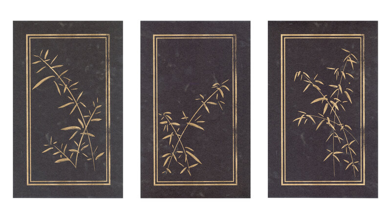 Three black rectangular panels with bamboo plants in a double gold border.